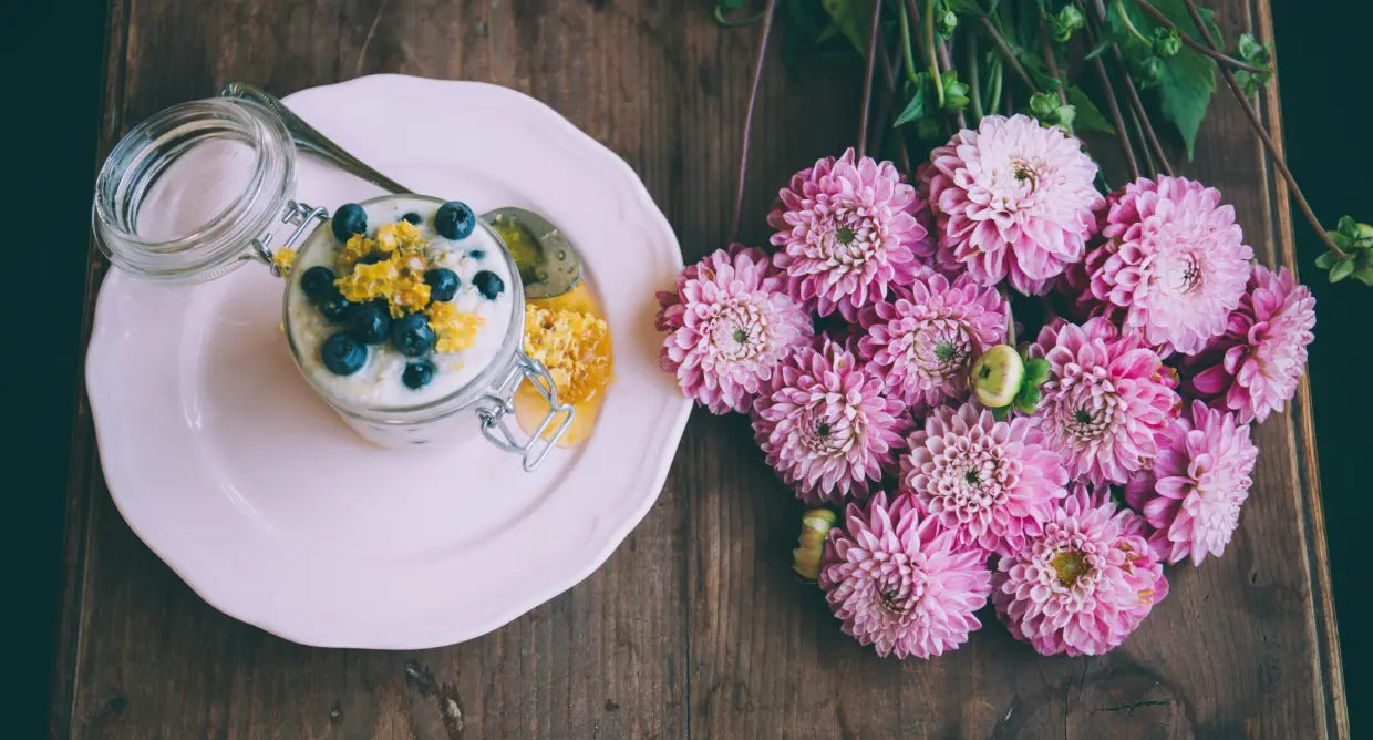yogurt and flower on wooden table